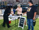 Visitors to Hanford's first Thursday night Market Place follow the rules with masks and checking in at the sanitation station.